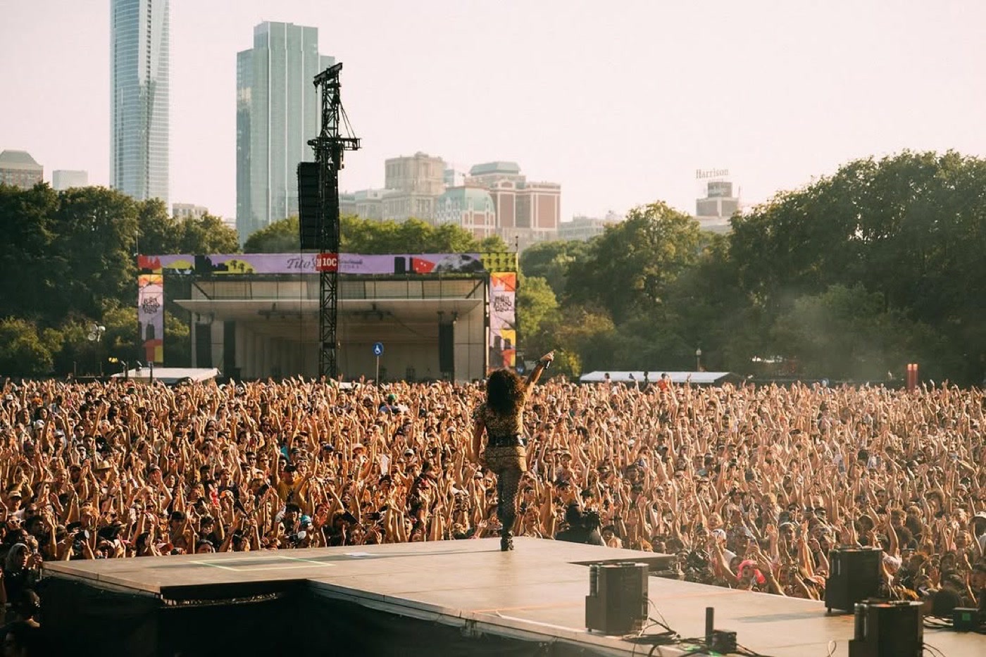 Remi Wolf on stage facing a festival crowd, Lollapalooza